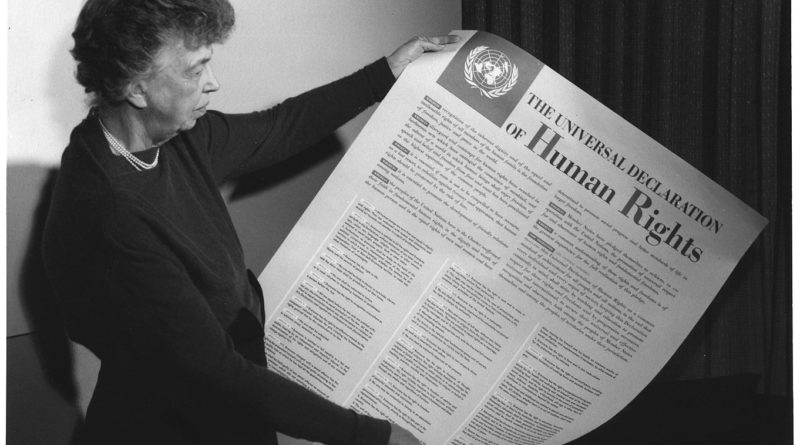 Eleanor Roosevelt. Black and white photo of women holding a large piece of paper.