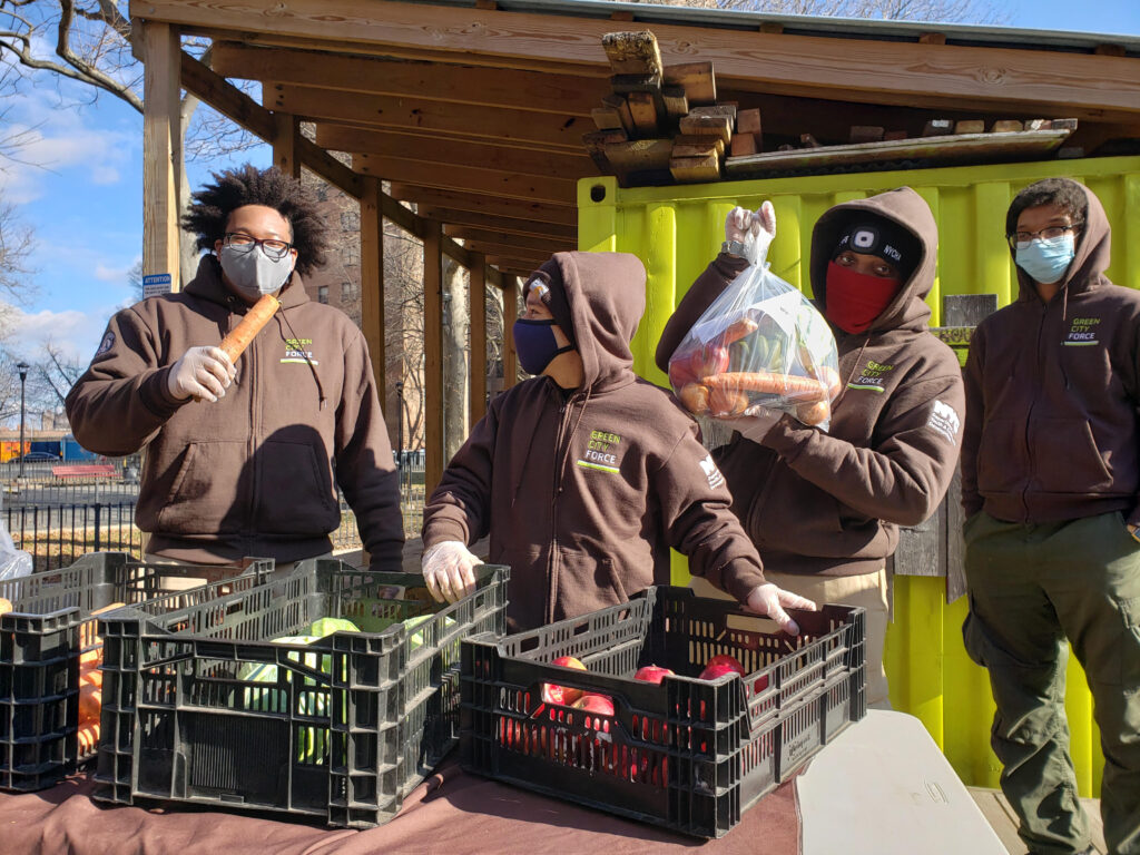 group of people in brown uniforms holding produce