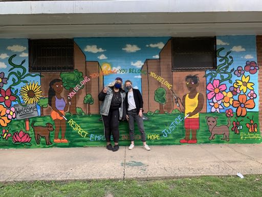 two people in front of mural
