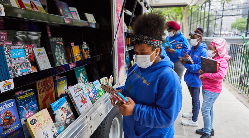 girls look at books in bookmobile