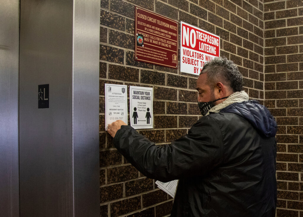 man posting flyers near elevator