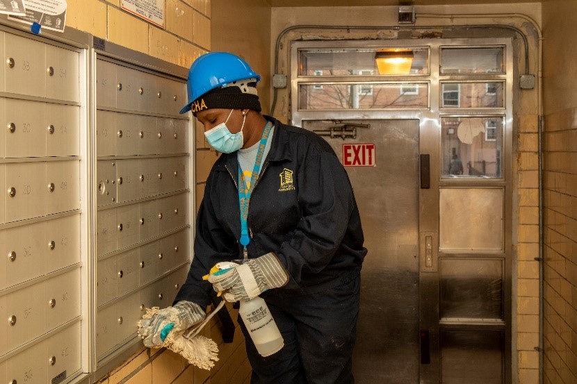 employee disinfecting mailboxes