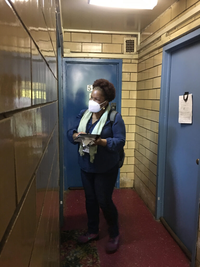 woman standing in a hallway outside of a NYCHA apartment