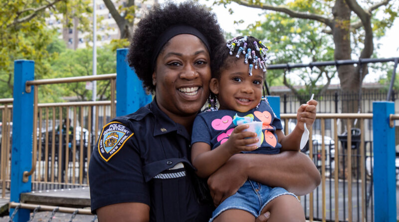 woman police officer holding a young child