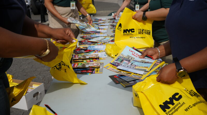 hands packing yellow bags with pamphlets