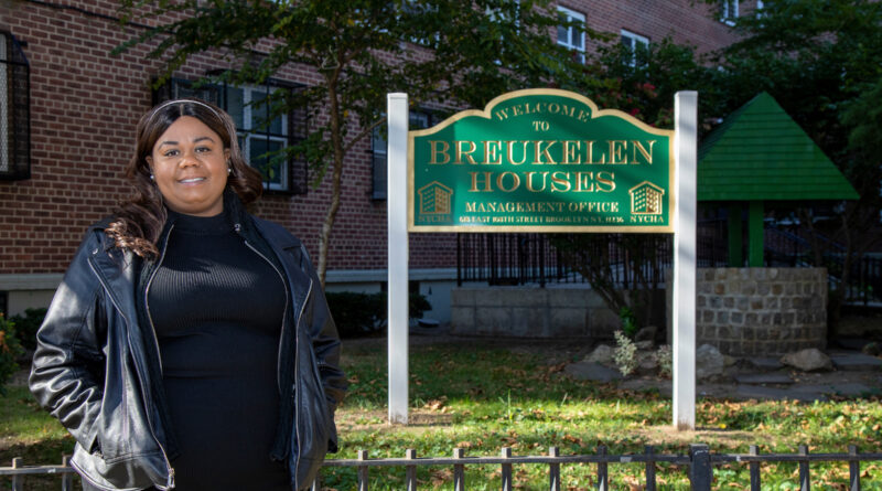 woman in front of sign for Breukelen Houses