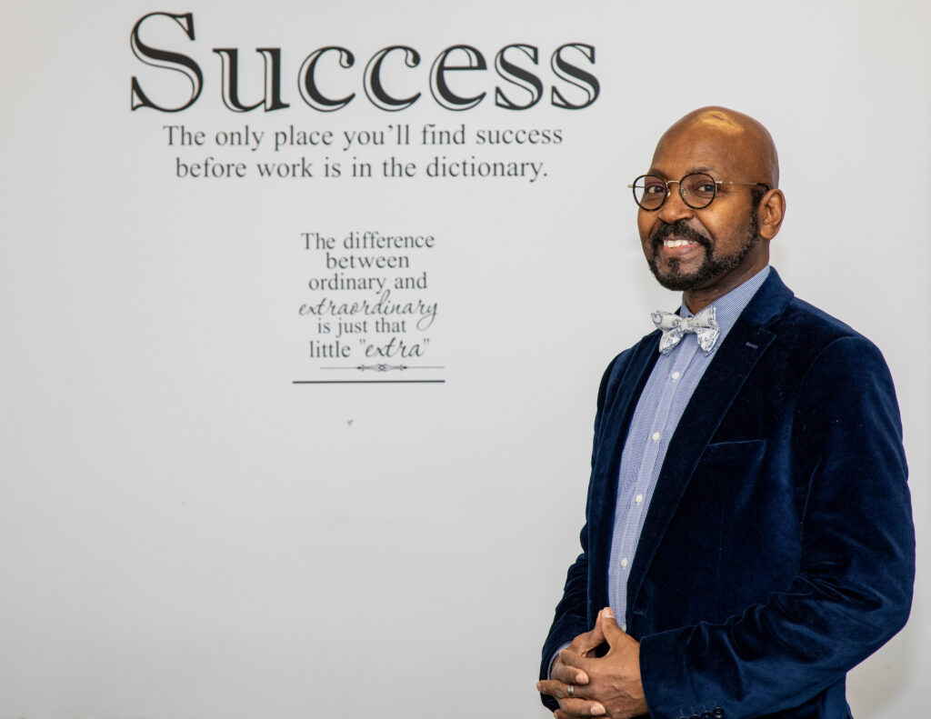 man standing in front of wall with the word "Success" on it