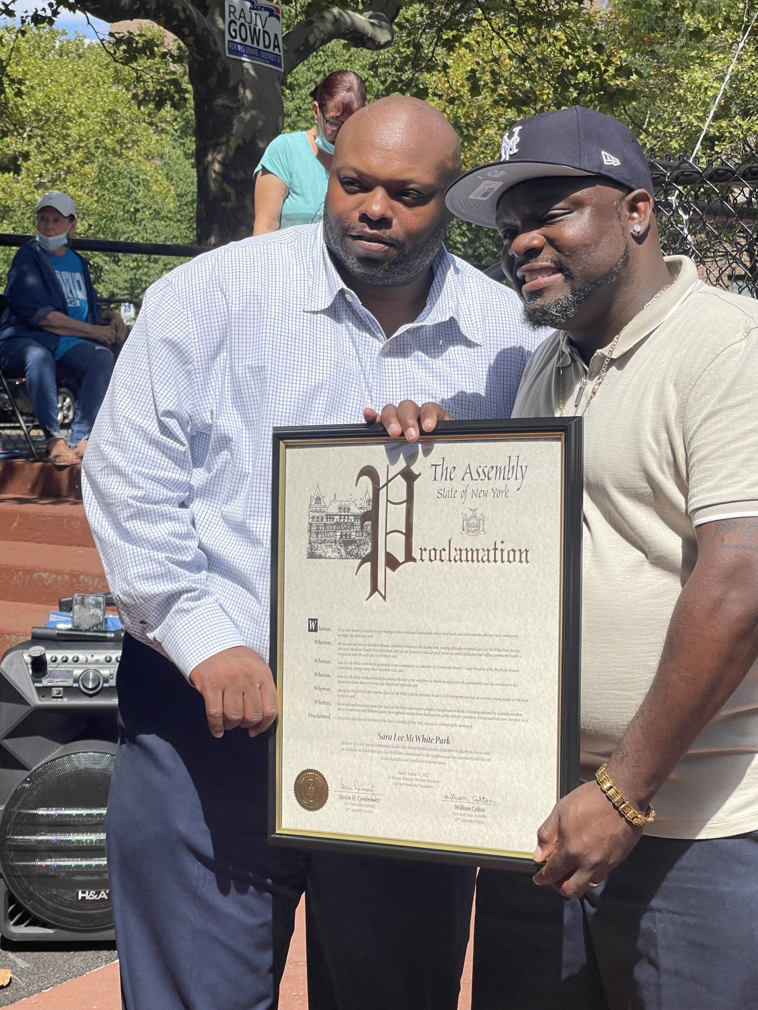 two men holding a framed proclamation