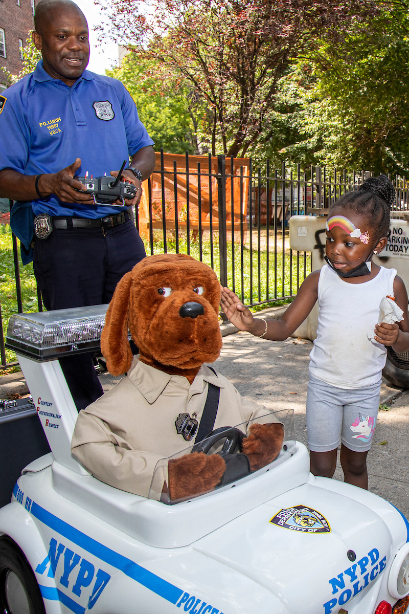 child, police officer, and stuffed dog in uniform