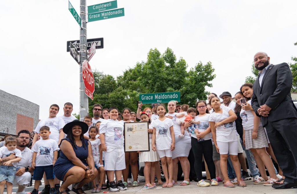 group of people standing beneath street sign