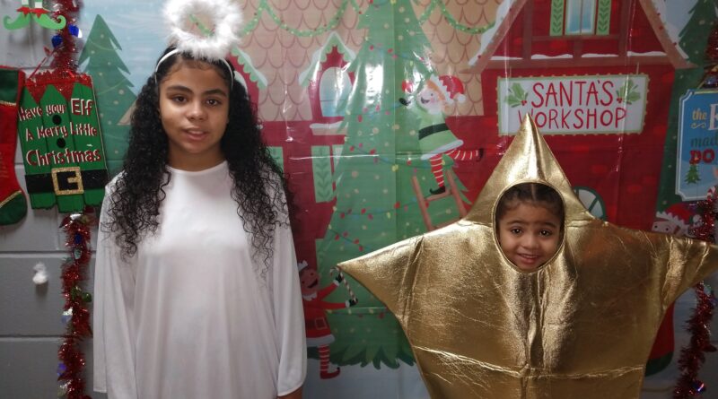 two children, one dressed up as an angel, another dressed up as a gold star