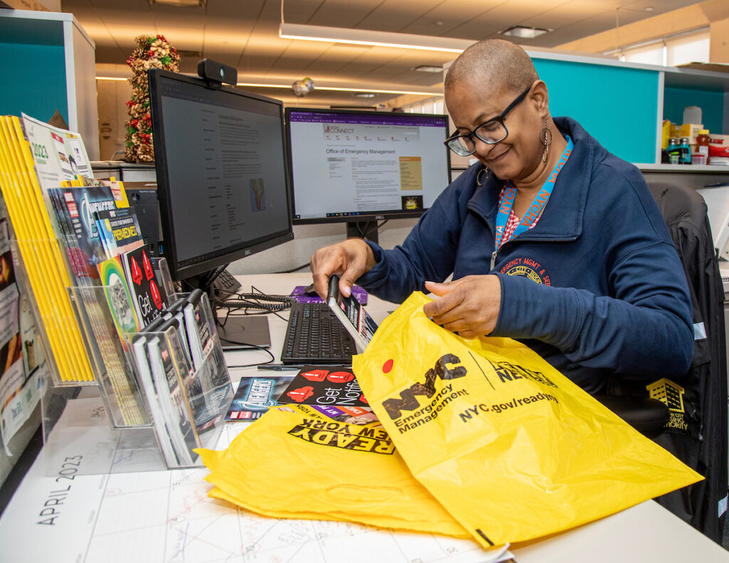 woman sitting at desk stuffing yellow bags