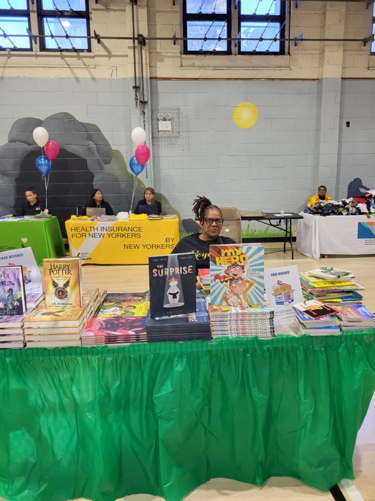 A woman offering children's books at the recent Healthy Start @ NYCHA resource fair.