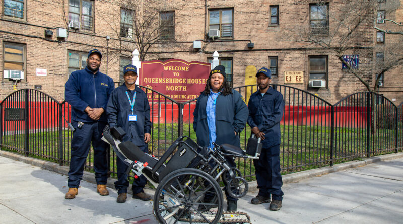 Caretakers at the Queensbridge Houses standing beside a stair climber device.