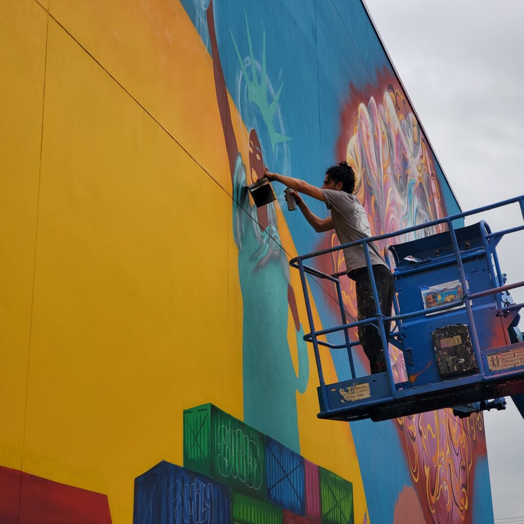 man spray painting mural