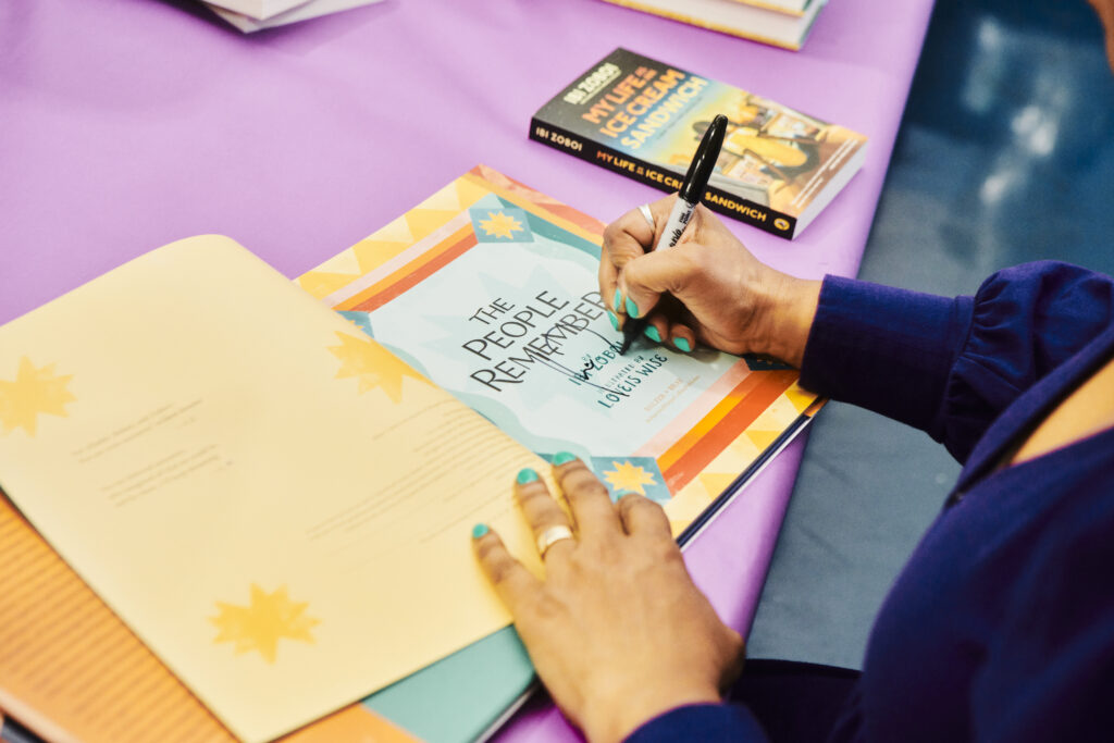 woman's hands signing children's book