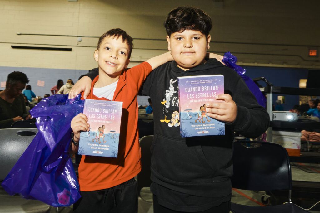 two kids holding books in Spanish