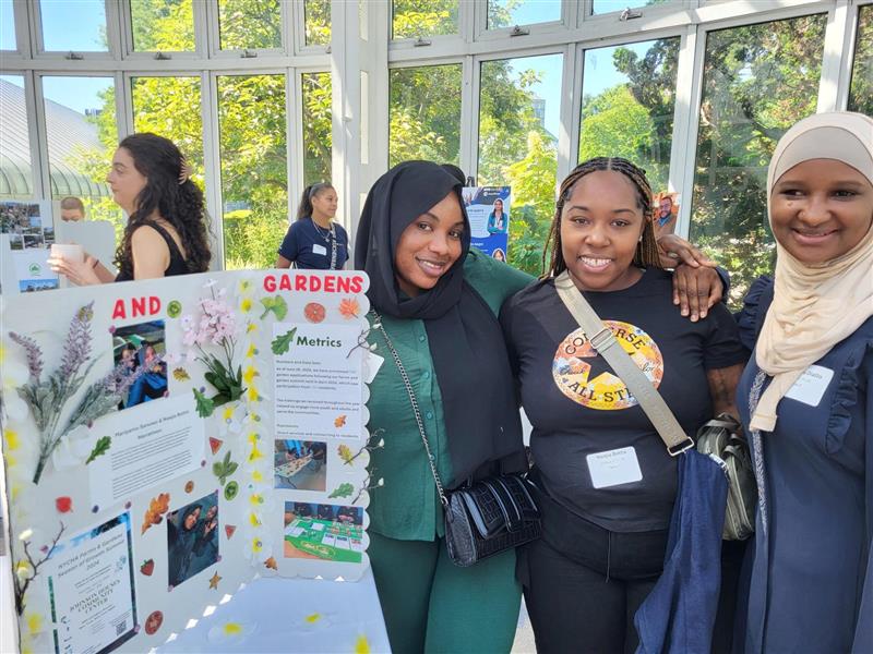 three people standing next to a posterboard presentation