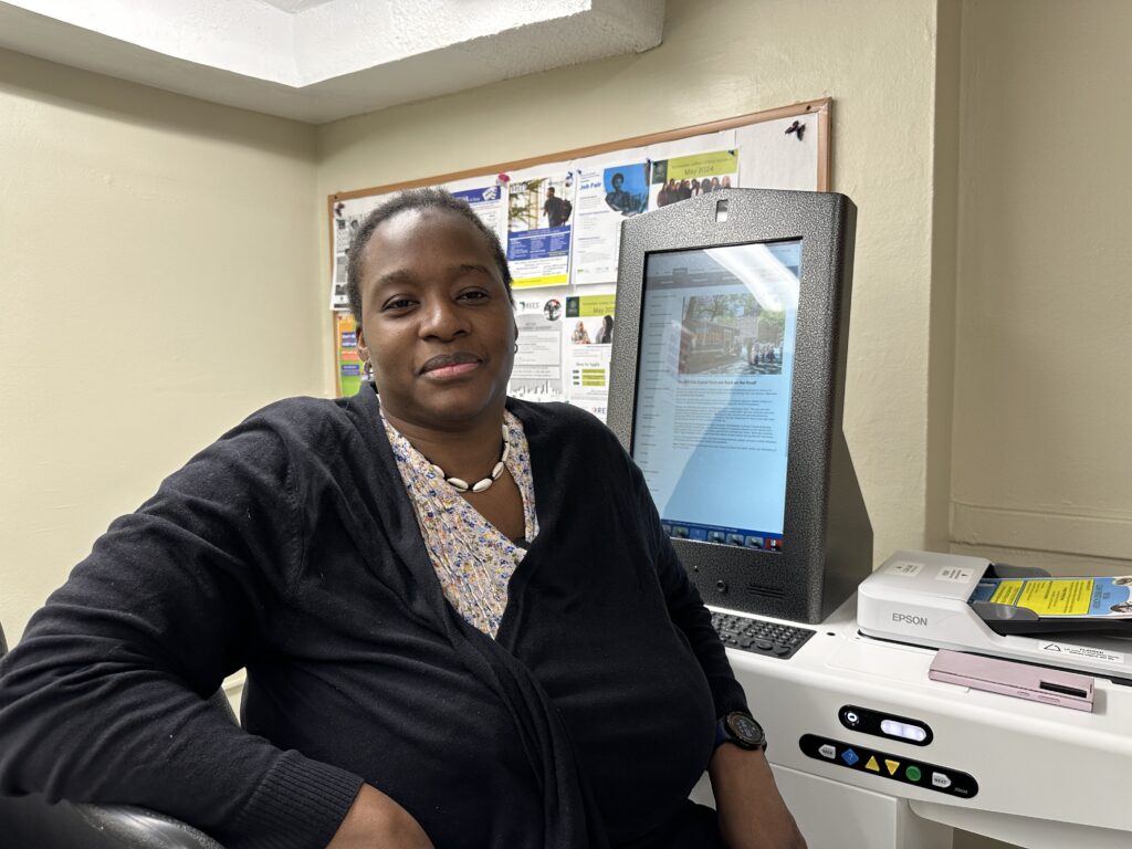 woman seated in front of self-service kiosk