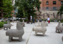 Nivola Horse statues at entrance of plaza, people walking around plaza