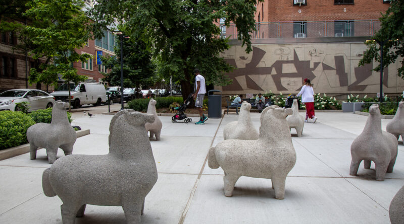 Nivola Horse statues at entrance of plaza, people walking around plaza