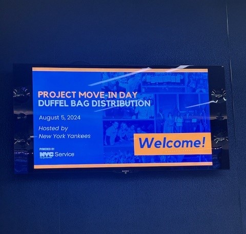 Large TV screen with text about Project Move-In Day