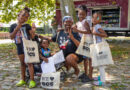 woman with four children who are all holding totebags