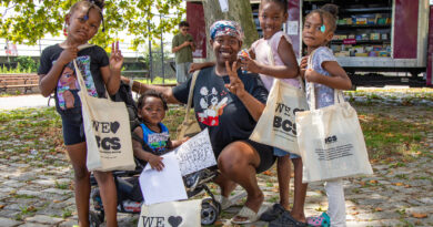 woman with four children who are all holding totebags