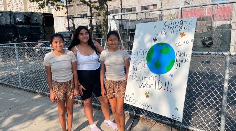 three girls in front of large poster board on an easel