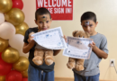 two boys holding teddy bears