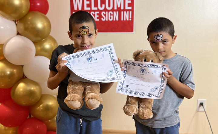 two boys holding teddy bears