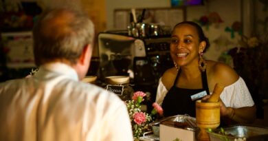 woman behind a counter serving a customer