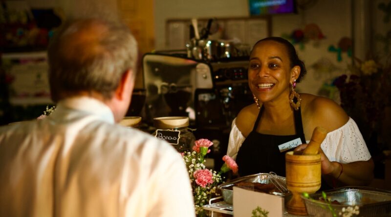 woman behind a counter serving a customer