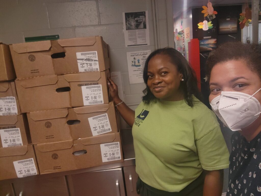 two women standing next to boxes