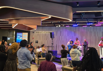 audience standing and looking at performers on stage