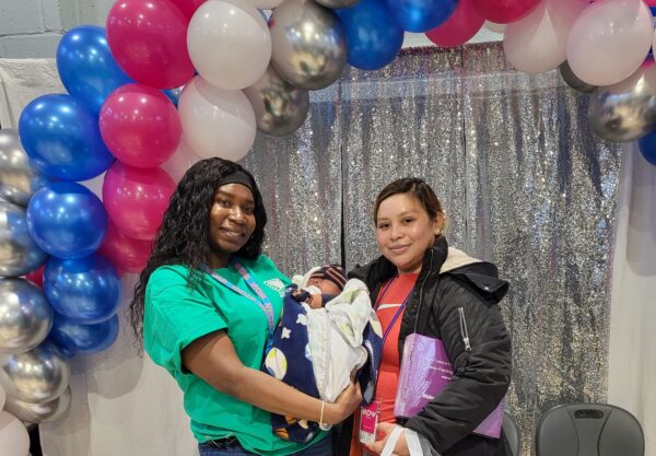two woman, one holds a baby