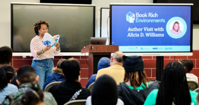 a woman reading from her book in front of an audience