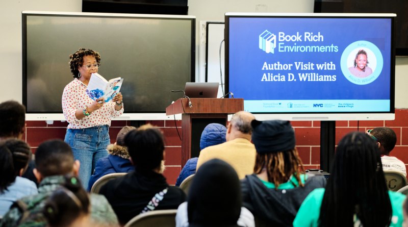 a woman reading from her book in front of an audience