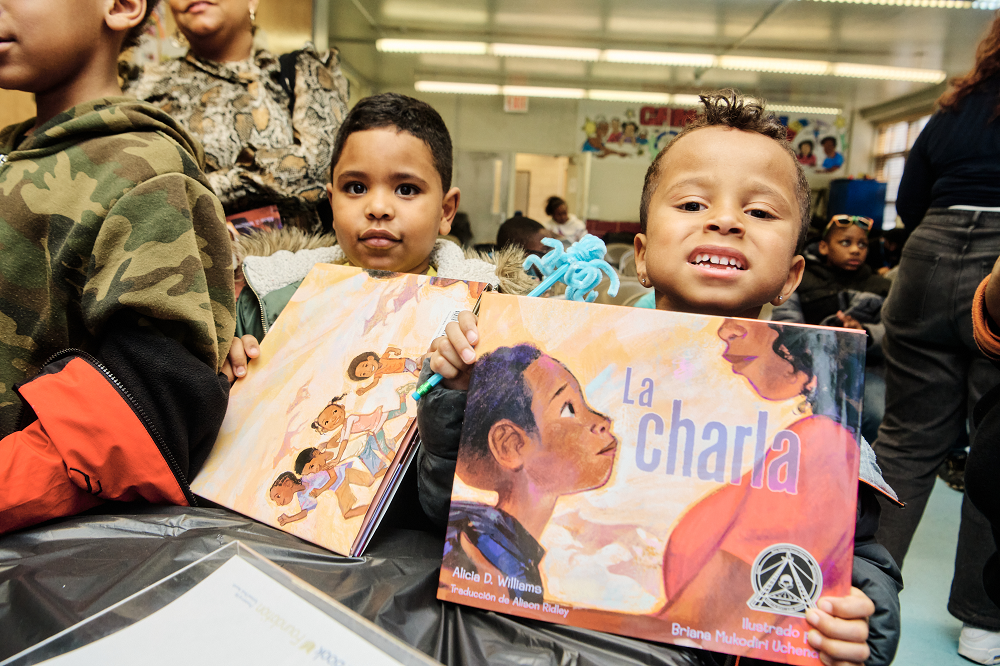 two children holding picture books