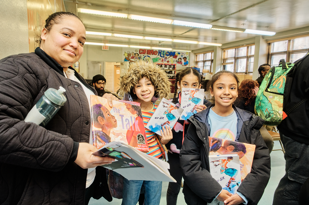 group of adults and children with books