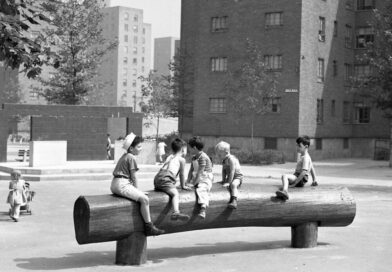 archival black and white photo of children playing in a playground located in a NYCHA development