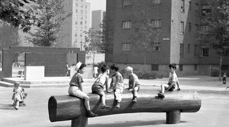 archival black and white photo of children playing in a playground located in a NYCHA development