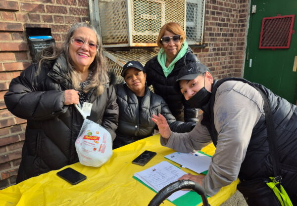 group of people, one holding a frozen turkey