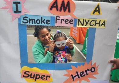 two people behind Smoke Free NYCHA sign