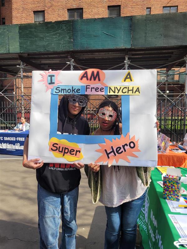 two people holding Smoke Free NYCHA sign