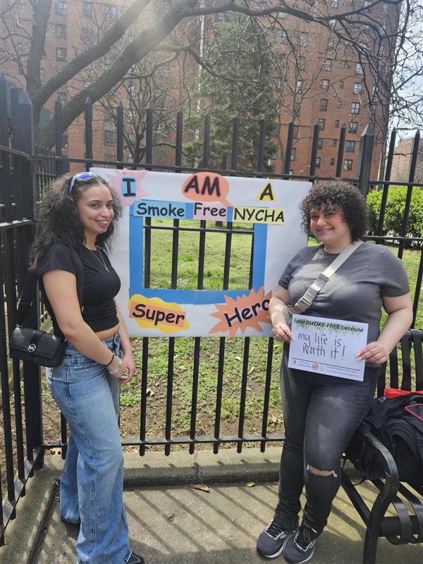 two women holding Smoke Free NYCHA sign