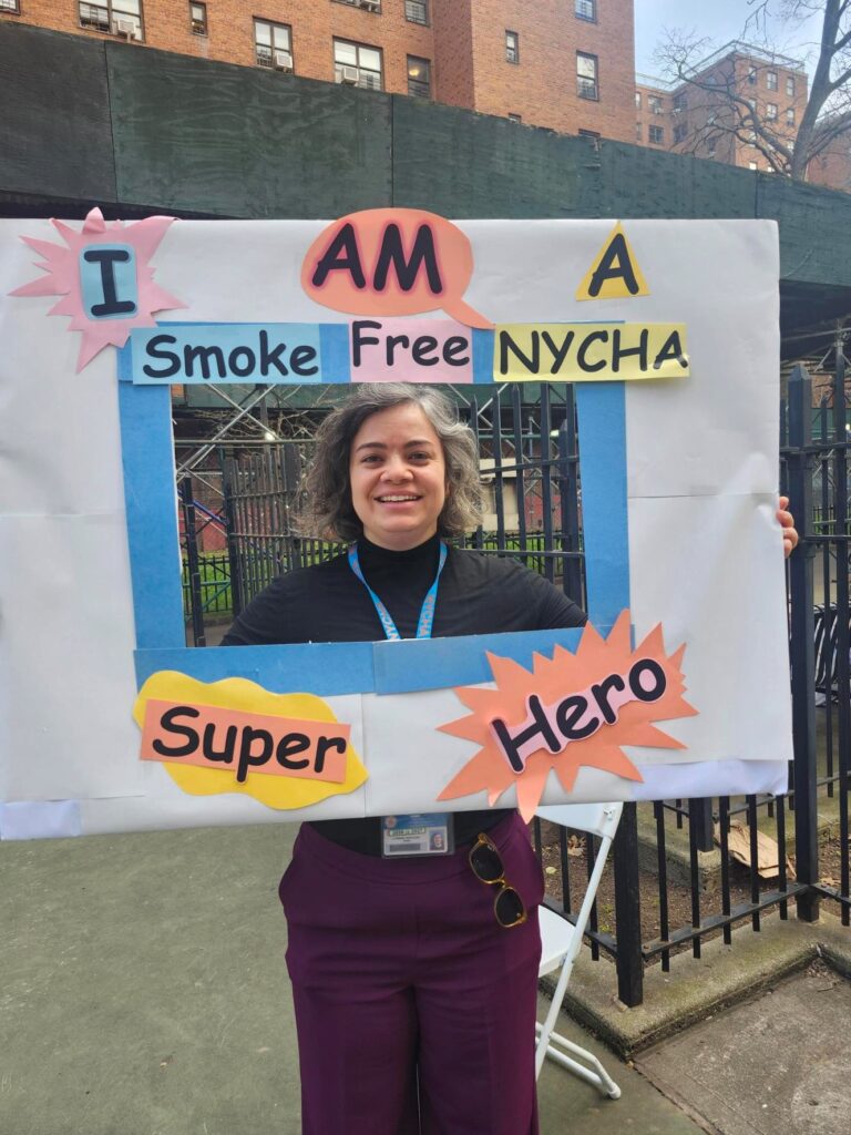 woman holding Smoke Free NYCHA sign