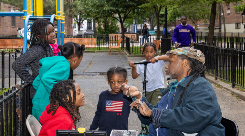 kids getting their faces painted by a man