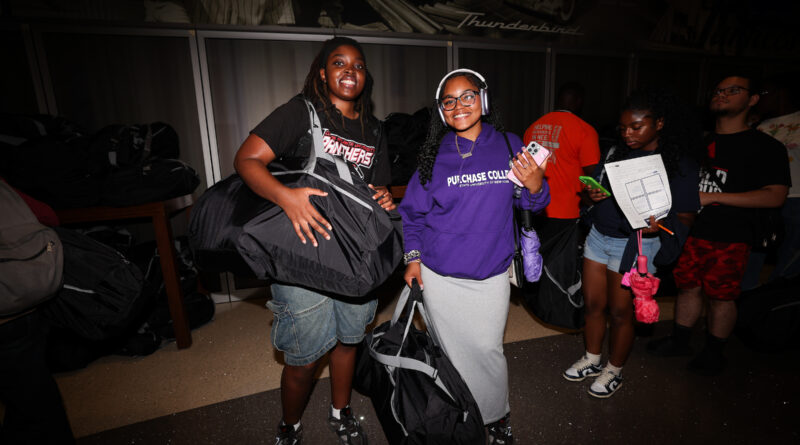 two people holding large duffel bags