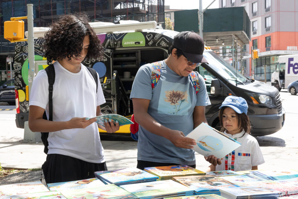 man and children looking at books